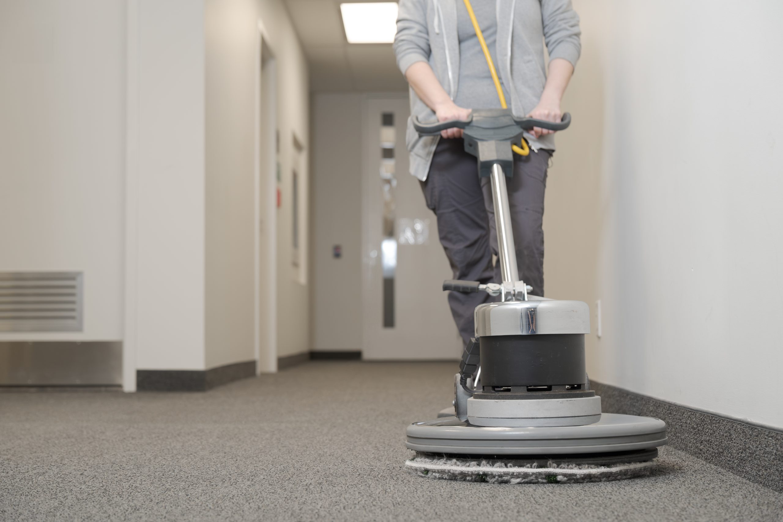 unrecognizable young woman cleaning a carpet , copy space